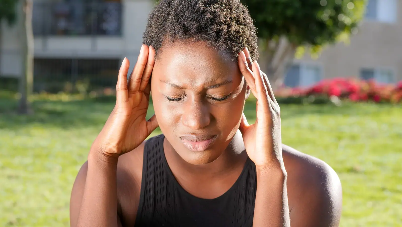 Woman holding her head, troubled by ringing in her ears