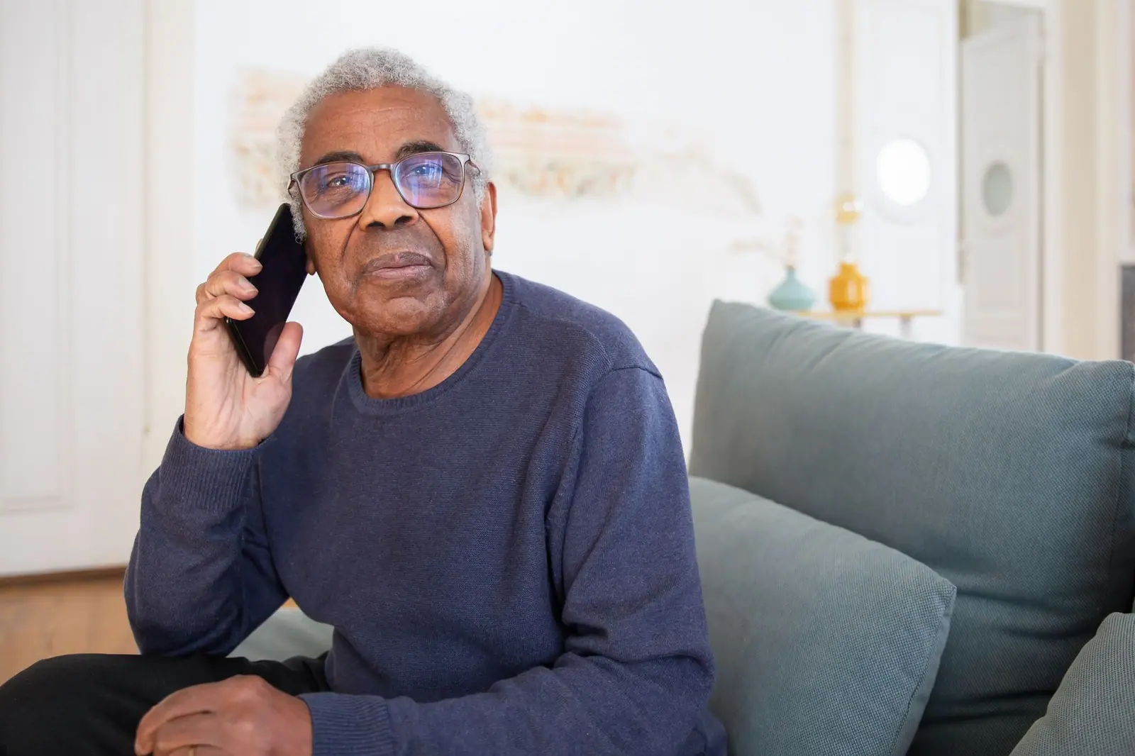 Older man calling on his mobile phone at home